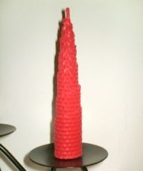 Red tapered candle made with rolled beeswax sheet.